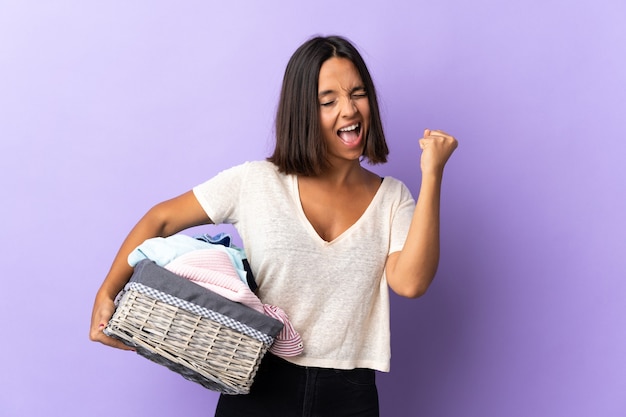 Giovane donna latina che tiene un cestino dei vestiti