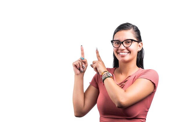 Giovane donna latina con occhiali sorridenti che puntano su sfondo bianco