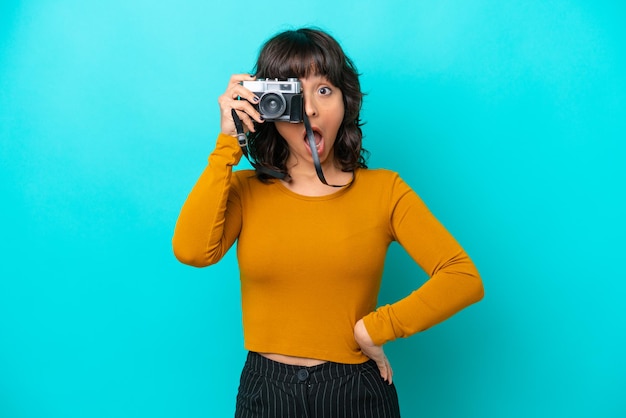 Giovane donna latina del fotografo isolata su sfondo blu