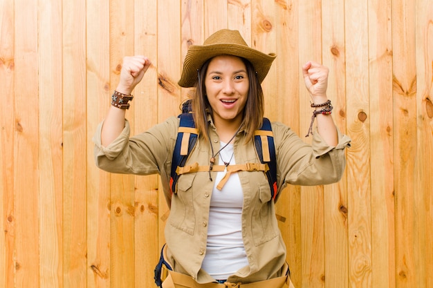 Giovane donna latina dell'esploratore contro la parete di legno della parete