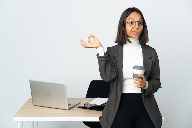 Giovane donna latina di affari che lavora in un ufficio isolato su bianco nella posa di zen