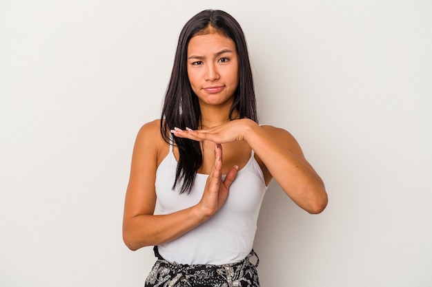 Giovane donna latina isolata su sfondo bianco che mostra un gesto di timeout.