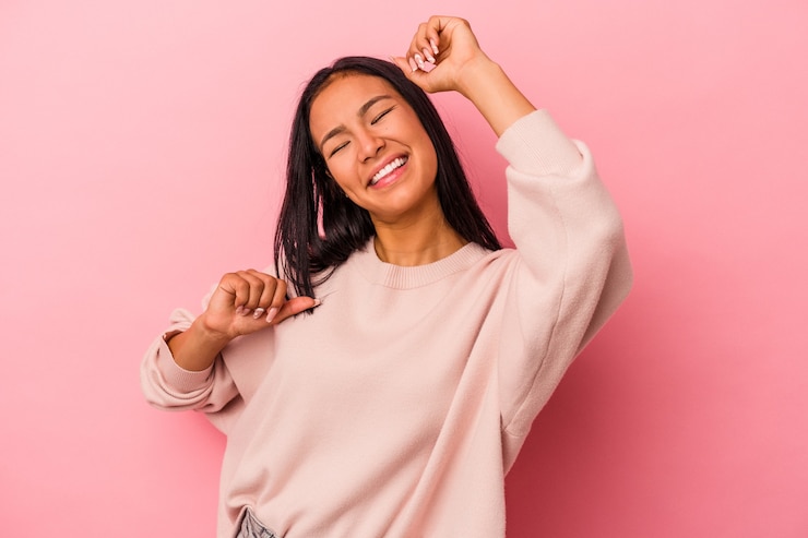 Foto giovane donna latina isolata su sfondo rosa che celebra un giorno speciale, salta e alza le braccia con energia.