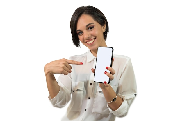 Giovane donna latinoamericana che indica il suo telefono cellulare con il suo grande sorriso di mano felice