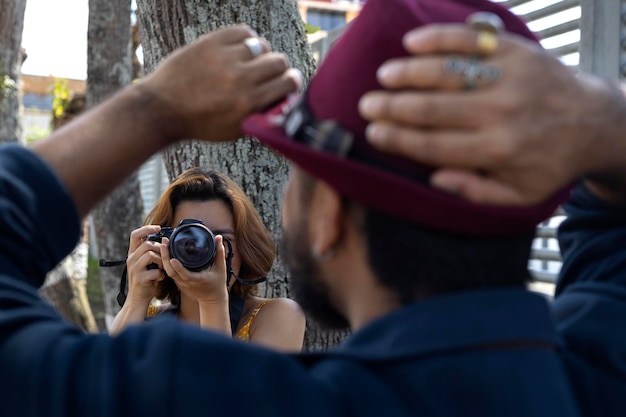 Giovane donna latinoamericana con la fotocamera in mano scatta foto del suo partner in vacanza Concetto di passeggiate e vacanze