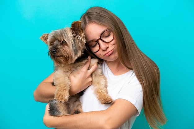 Giovane donna lituana che tiene un cane isolato su sfondo blu