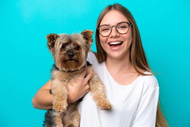 Giovane donna lituana che tiene un cane isolato su sfondo blu