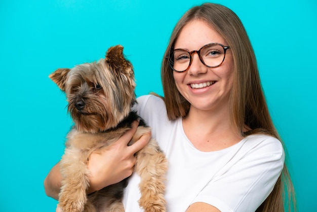 Giovane donna lituana che tiene un cane isolato su sfondo blu