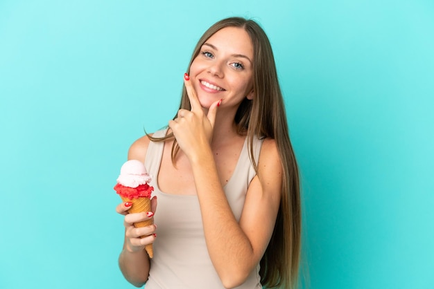 Giovane donna lituana con gelato alla cornetta isolato su sfondo blu felice e sorridente