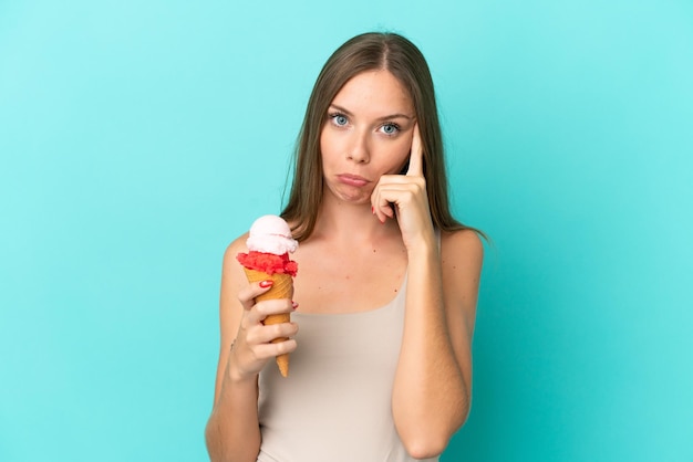 Giovane donna lituana con gelato alla cornetta isolato su sfondo blu pensando a un'idea