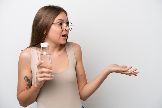 Giovane donna lituana con una bottiglia d'acqua isolata su sfondo bianco con espressione facciale a sorpresa