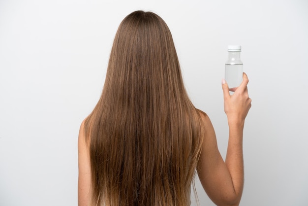Giovane donna lituana con una bottiglia d'acqua isolata su sfondo bianco in posizione posteriore