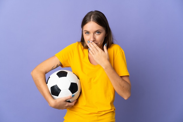 Giovane donna lituana del calciatore isolata sulla parete viola felice e sorridente che copre la bocca con la mano