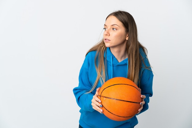 Giovane donna lituana isolata su sfondo bianco, giocando a basket