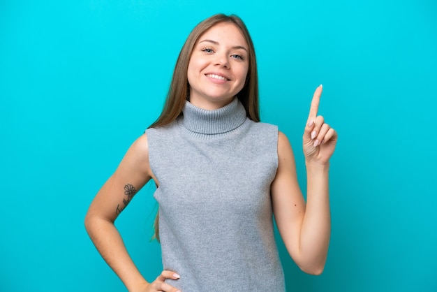 Giovane donna lituana isolata su sfondo blu che mostra e alza un dito in segno di meglio