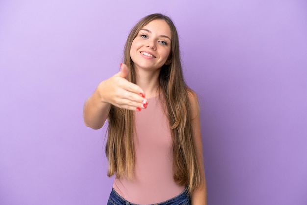 Giovane donna lituana isolata su sfondo viola che stringe la mano per aver chiuso un buon affare