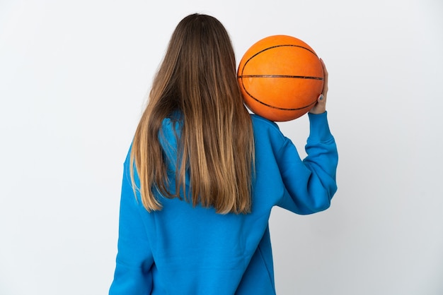 Giovane donna lituana isolata sul muro bianco, giocando a basket in posizione posteriore