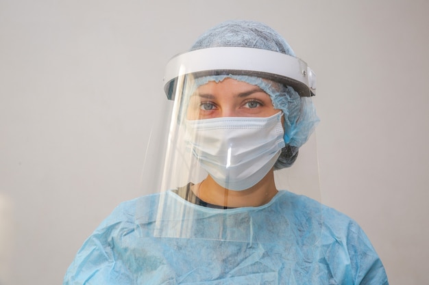 giovane donna medico infermiere in maschera protettiva su sfondo bianco