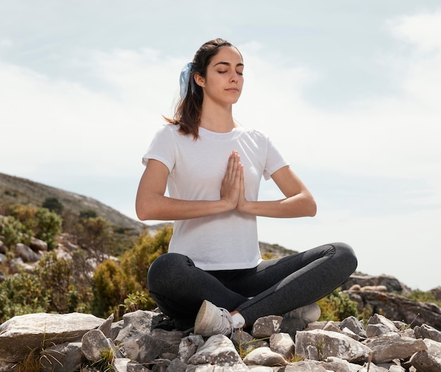 Giovane donna meditando all'aperto