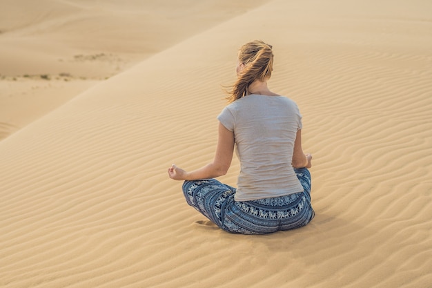 Giovane donna meditando nel deserto, Vietnam