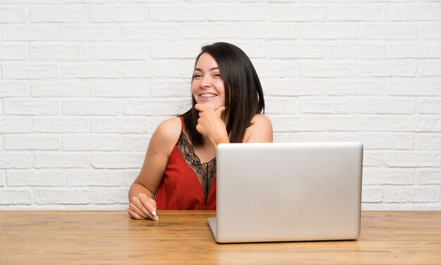 Giovane donna messicana con un laptop pensando un&#39;idea