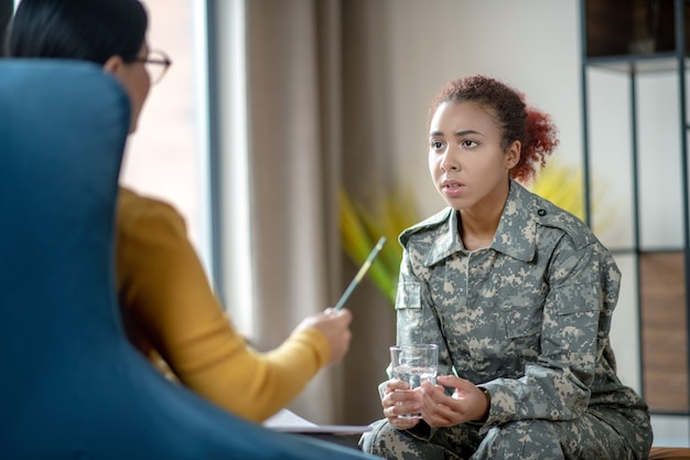 Giovane donna militare che parla con uno psicoterapeuta