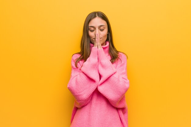 Giovane donna moderna che prega molto felice e sicura