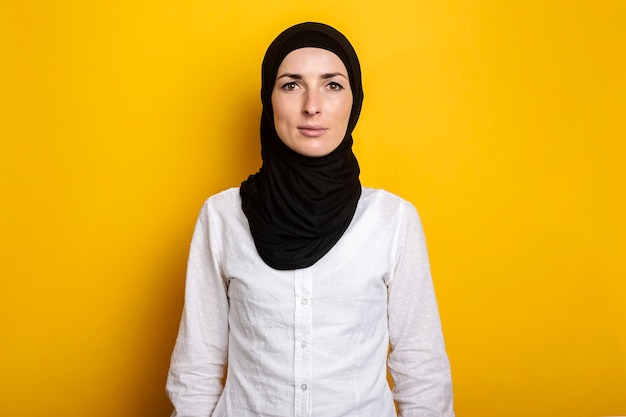 Giovane donna musulmana allegra in hijab su un giallo