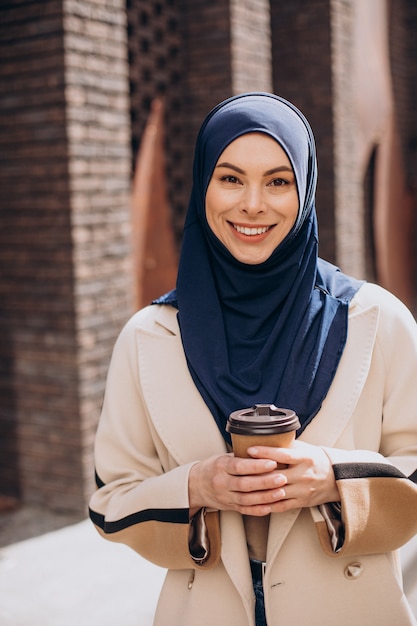 Giovane donna musulmana che beve caffè