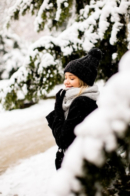 Giovane donna n vestiti caldi godendo nella neve