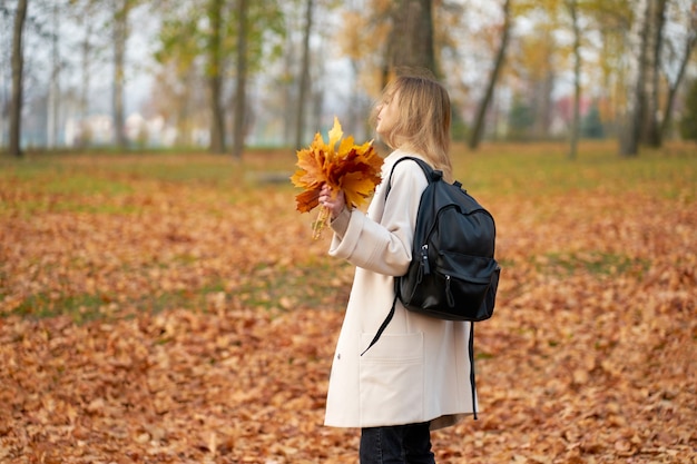 Giovane donna nel parco in autunno