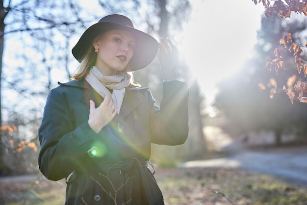 Giovane donna nella foresta con cappello e sole