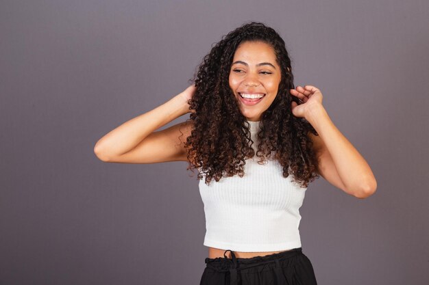 Giovane donna nera brasiliana che armeggia con i capelli ricci afro ricci