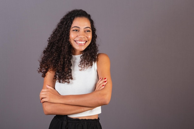 Giovane donna nera brasiliana con le braccia incrociate sorridente