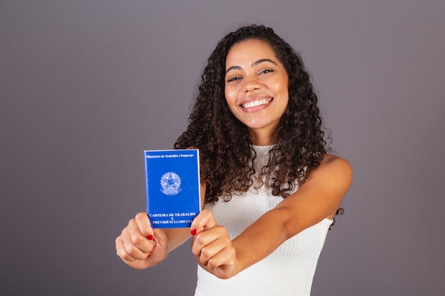 Giovane donna nera brasiliana con portafoglio da lavoro CLT Carta di previdenza sociale e lavoro