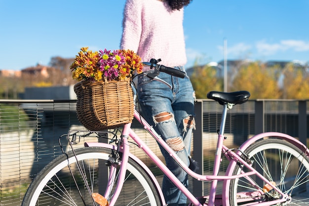 Giovane donna nera in sella a una bicicletta d'epoca