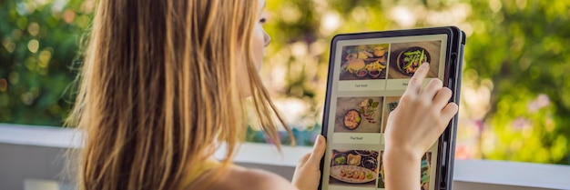 Giovane donna ordina cibo per il pranzo online usando Tablet BANNER LONG FORMAT
