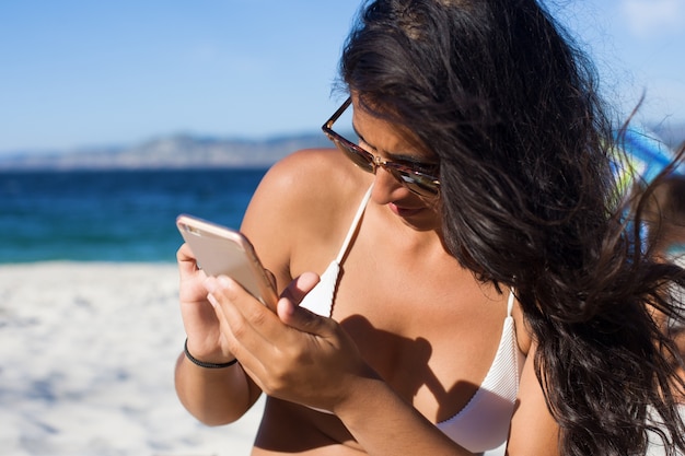 giovane donna parla al telefono in spiaggia