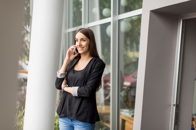 Giovane donna parlando al telefono davanti all&#39;ufficio