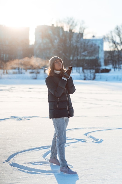 Giovane donna pattinaggio su ghiaccio, sport invernali, neve, divertimento invernale. Donna che impara a pattinare sul lago, natura, giornata di sole.