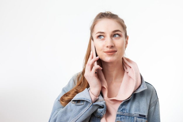 Giovane donna piuttosto caucasica che parla al telefono isolato su sfondo bianco