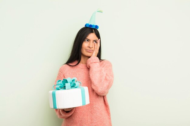 Giovane donna piuttosto ispanica che si sente annoiata, frustrata e assonnata dopo un noioso concetto di torta di compleanno