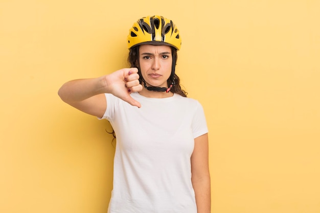 giovane donna piuttosto ispanica che si sente croce, mostrando i pollici verso il basso. concetto di bicicletta