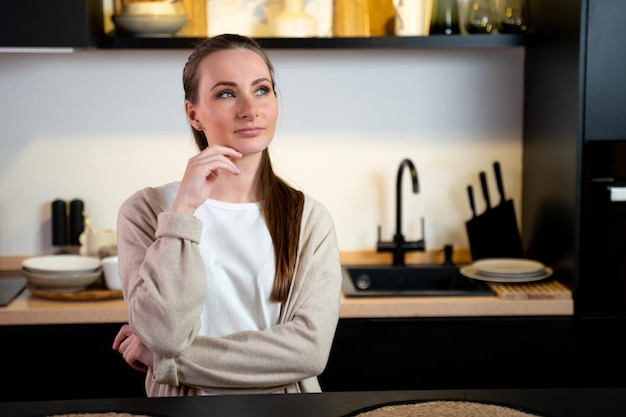 Giovane donna premurosa in cucina a casa