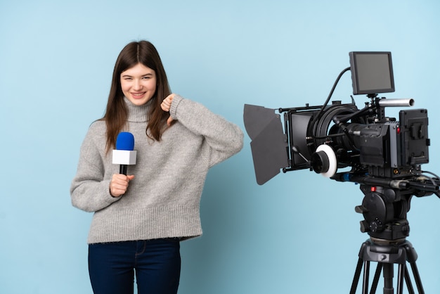 Giovane donna reporter che tiene un microfono e riporta notizie orgogliose e soddisfatte di sé