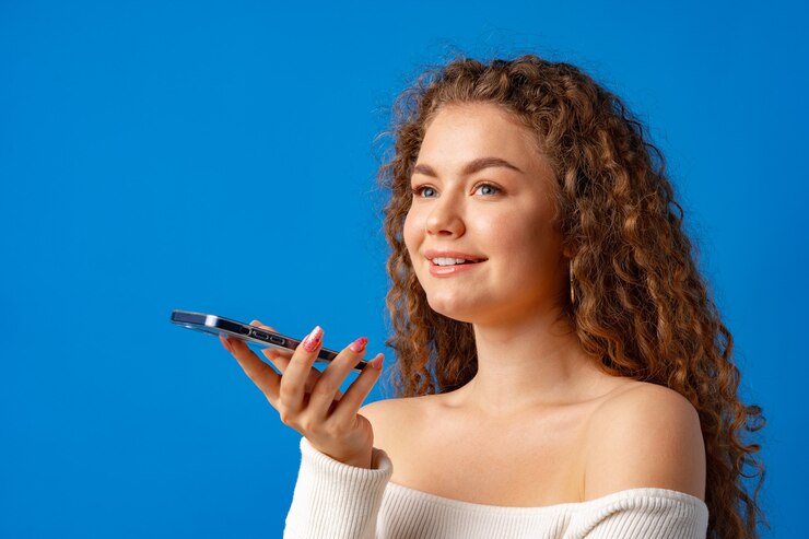 Foto giovane donna riccia che parla al telefono su sfondo blu