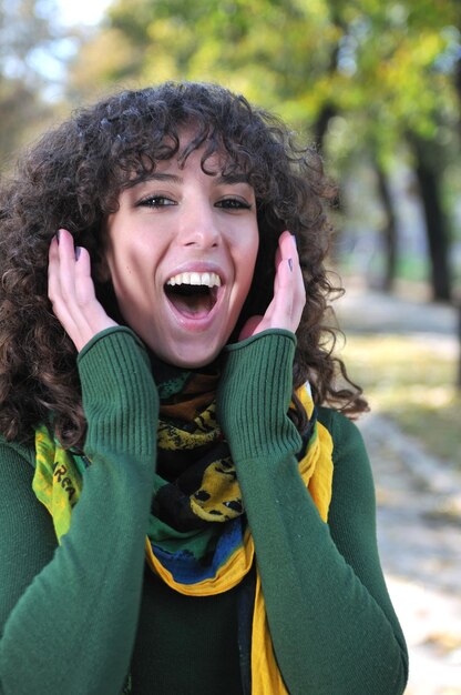 Giovane donna riccia che stride all'aperto in natura