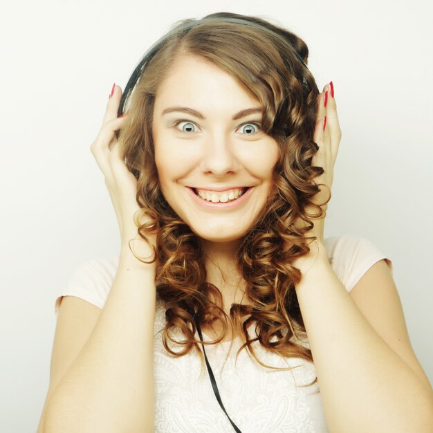 Giovane donna riccia con musica d'ascolto delle cuffie.