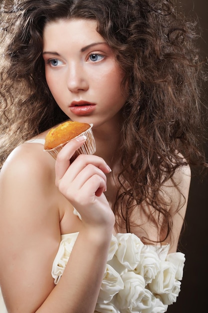 Giovane donna riccia con una torta