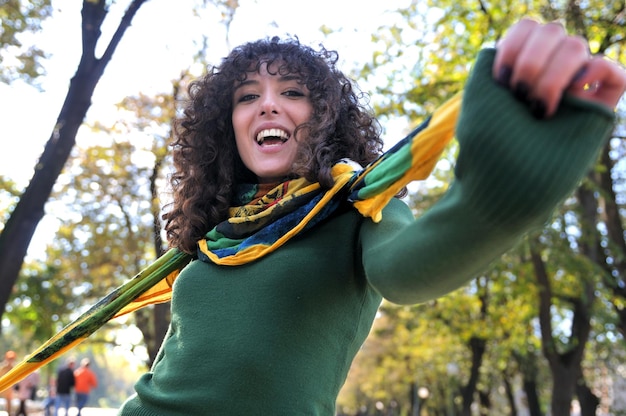 Giovane donna riccia sorridente all'aperto in natura